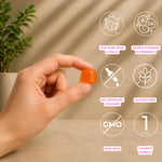 A hand holds a translucent orange gummy against a warm beige background with soft leaf shadows. White circular icons with pink text highlight product benefits: for hair, skin, and nails; added vitamins and minerals; no artificial colors; gluten free; non-GMO; and a 1-month supply.