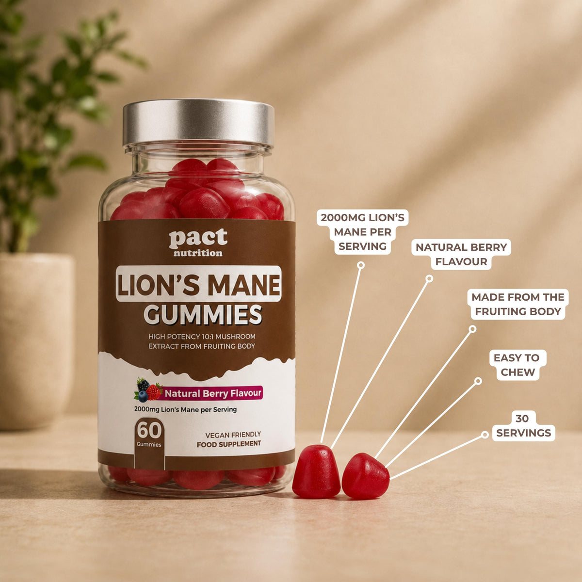 A bottle of Pact Nutrition Lion's Mane Gummies in natural berry flavour, shown on a wooden surface with two loose gummies in front. White callout lines with text highlight key features: 2000mg lion's mane per serving, natural berry flavour, made from the fruiting body, easy to chew, and 30 servings.